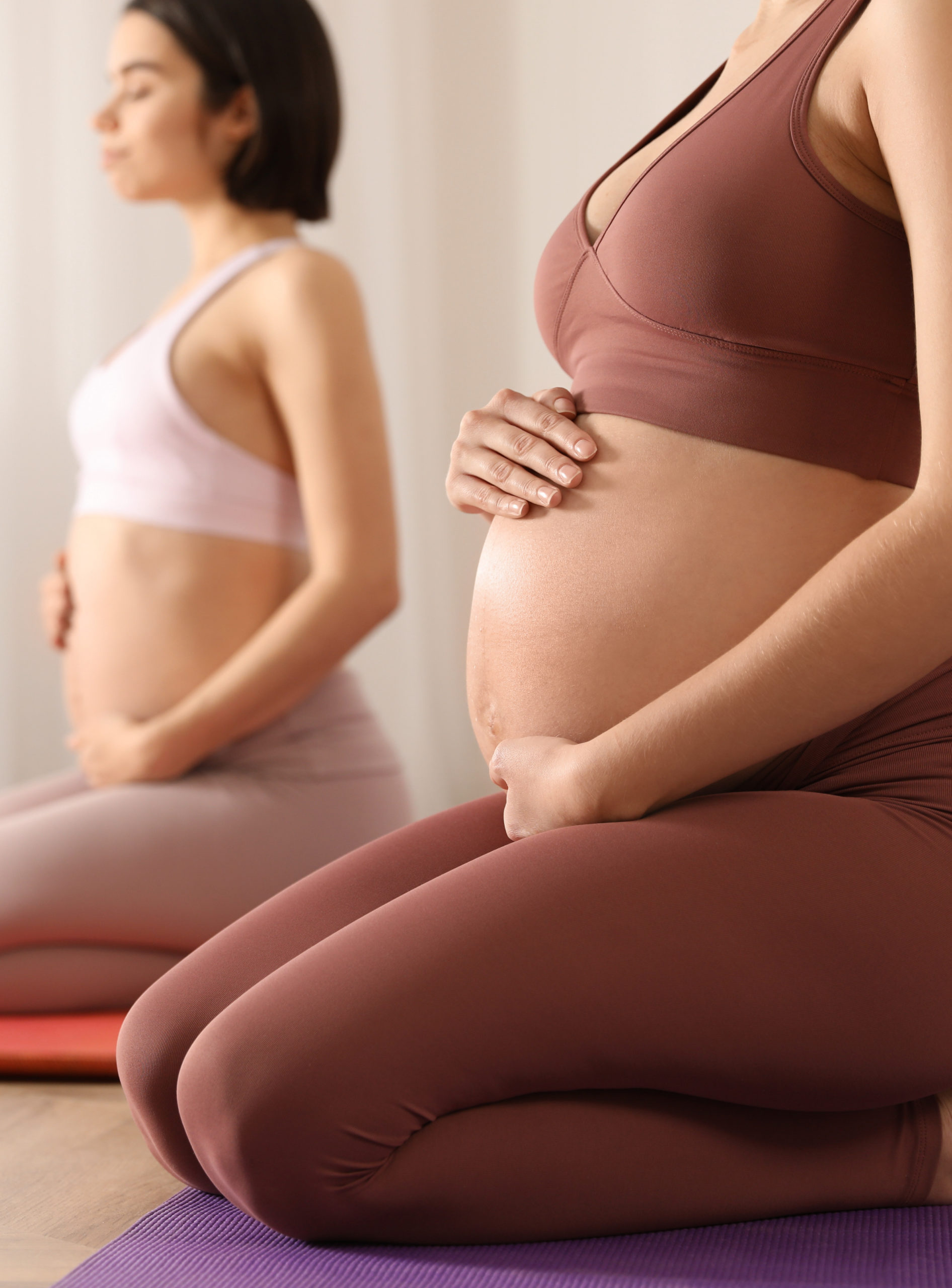 Group of pregnant women practicing yoga in gym, closeup